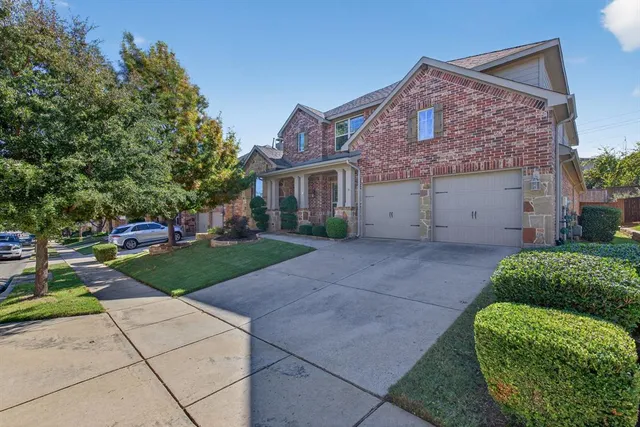 a front view of a house with a yard and trees