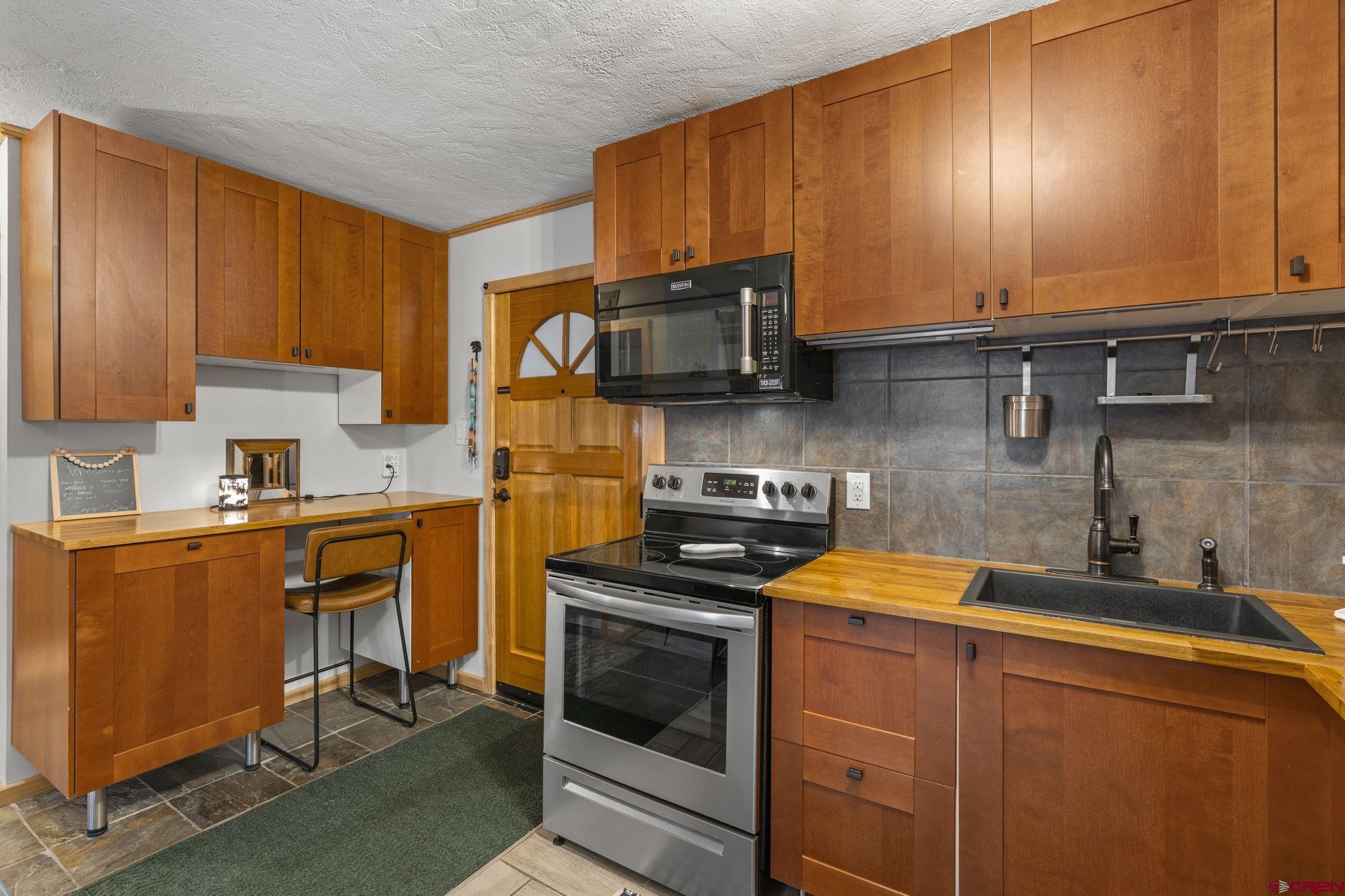 455 Sheol Street, Unit 109 Durango, CO 81301 - Photo 9 of 31 a kitchen with stainless steel appliances a stove a sink and a microwave