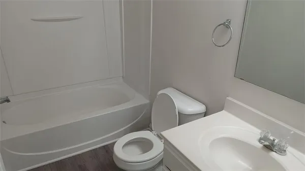 a white toilet sitting next to a bath tub