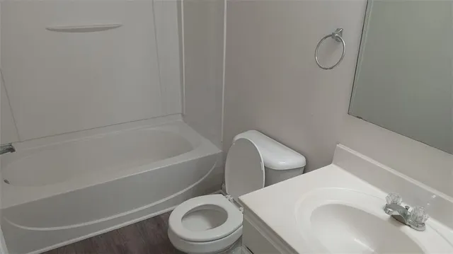 a white toilet sitting next to a bath tub