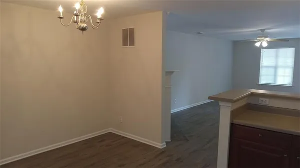 a view of a room with wooden floor and chandelier