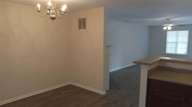 a view of a room with wooden floor and chandelier