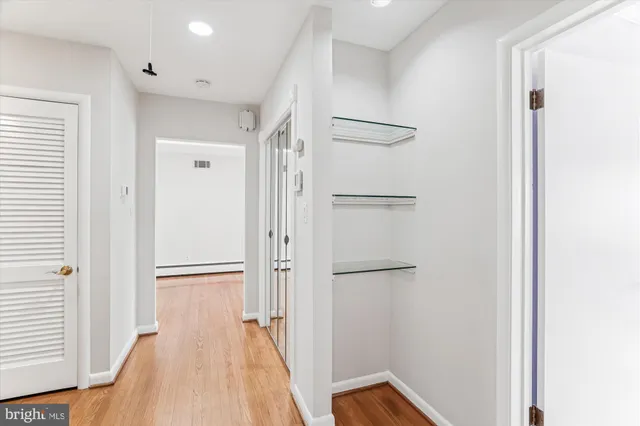 an empty room with wooden floor chandelier fan and windows