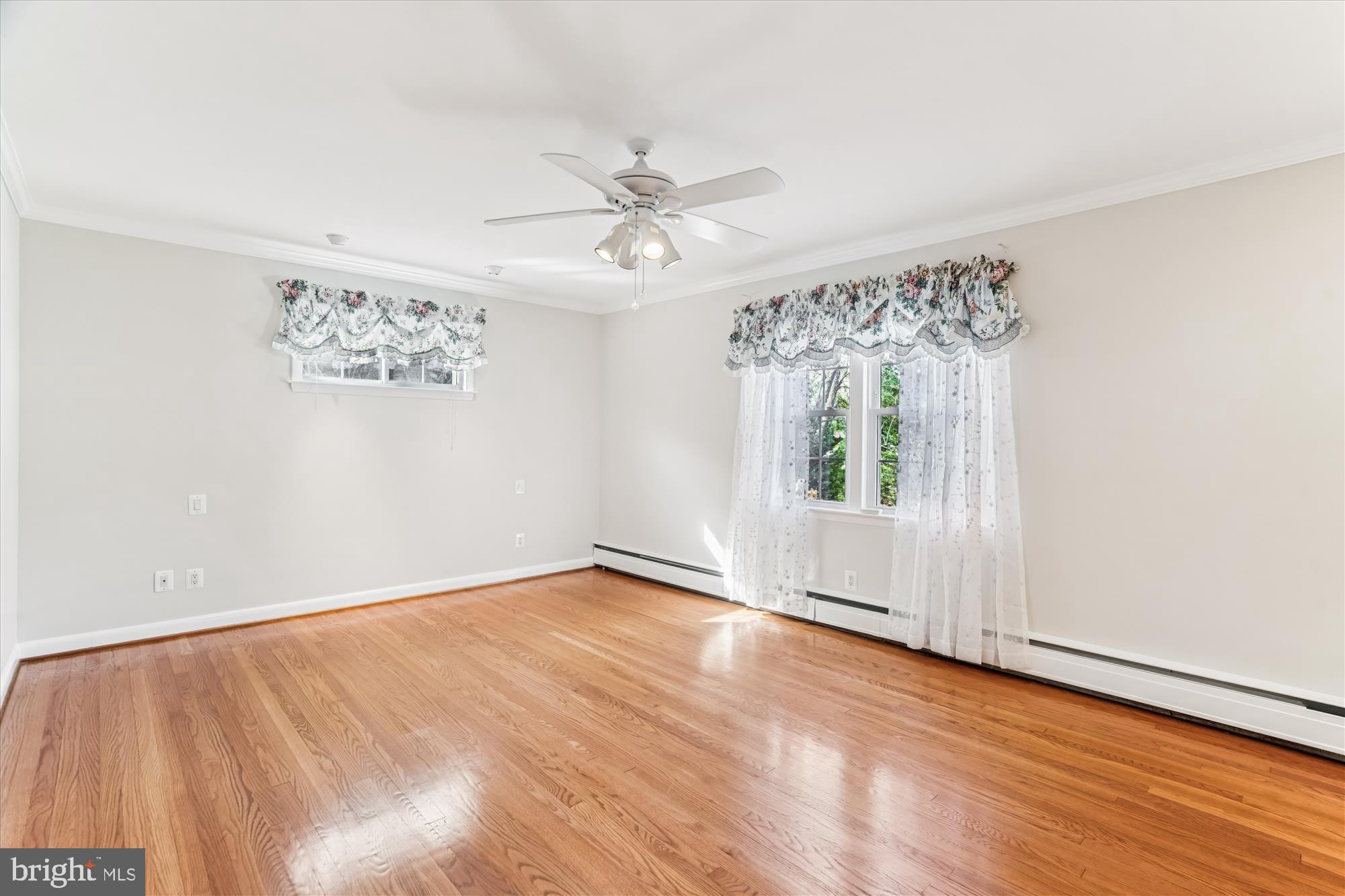 5813 Midhill Street Bethesda, MD 20817 - Photo 23 of 55 an empty room with wooden floor chandelier fan and windows