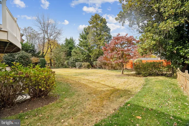 a view of a house with backyard and trees