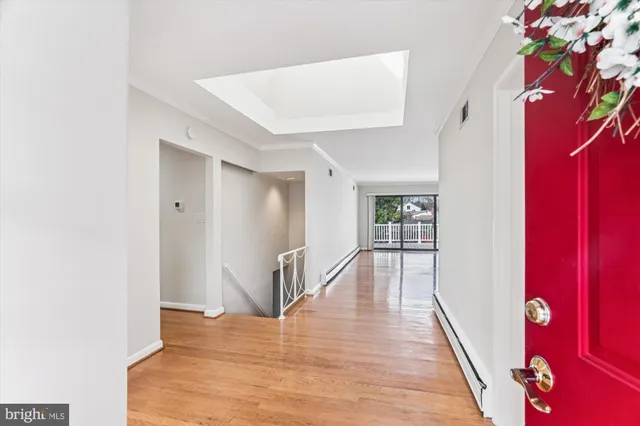 an empty room with wooden floor and a fireplace