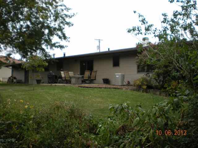 201 West Division Road Shannon, IL 61078 - Photo 2 of 12 a backyard of a house with table and chairs plants and large tree