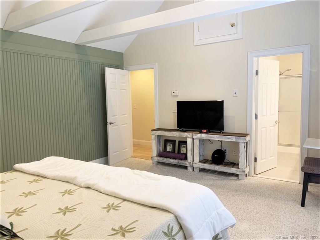 17 Spring Glen Road, Unit A East Lyme, CT 06357 - Photo 27 of 32 a bedroom with a flat screen tv and a bed