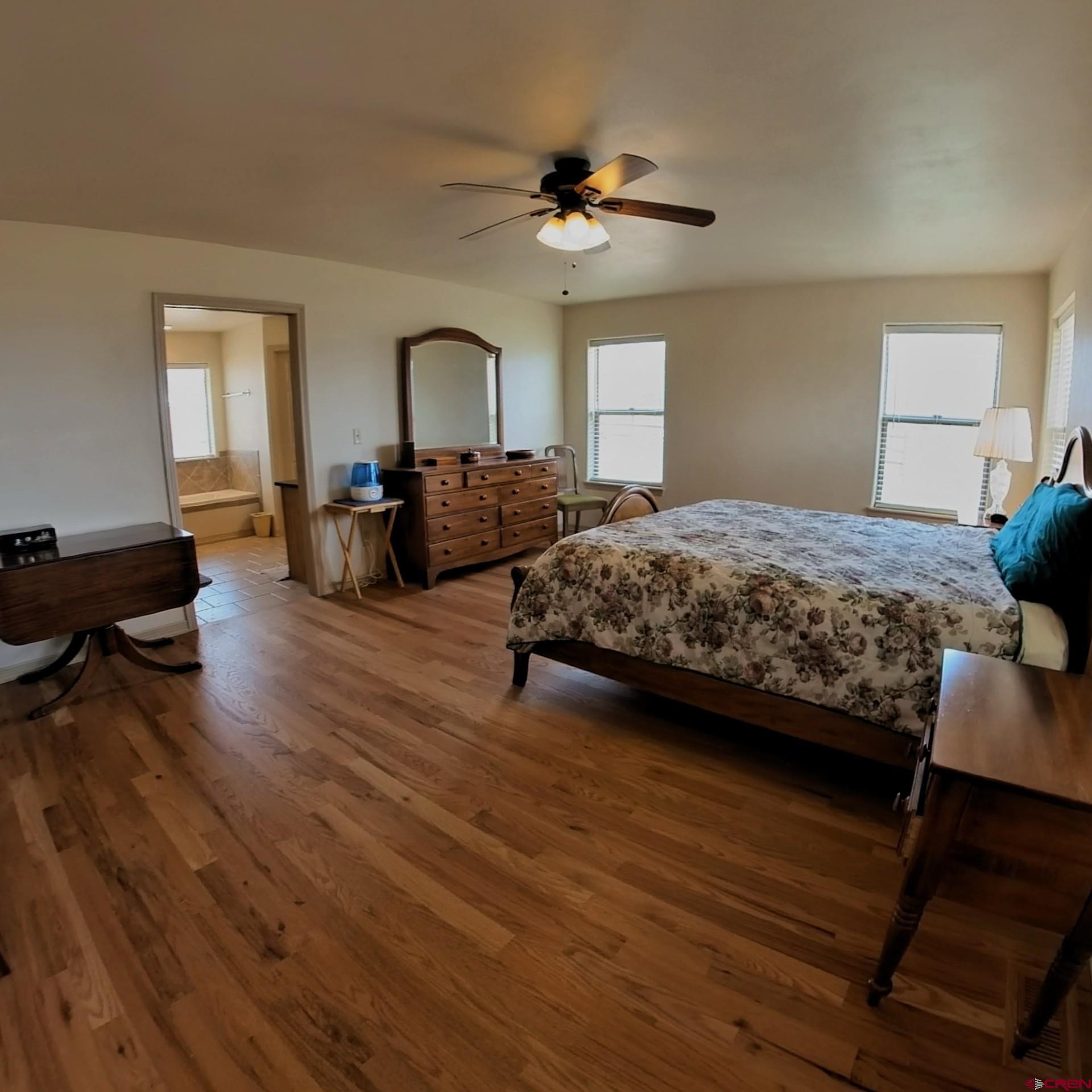 18200 Surface Creek Road Cedaredge, CO 81413 - Photo 18 of 39 a bedroom with bed and a chandelier