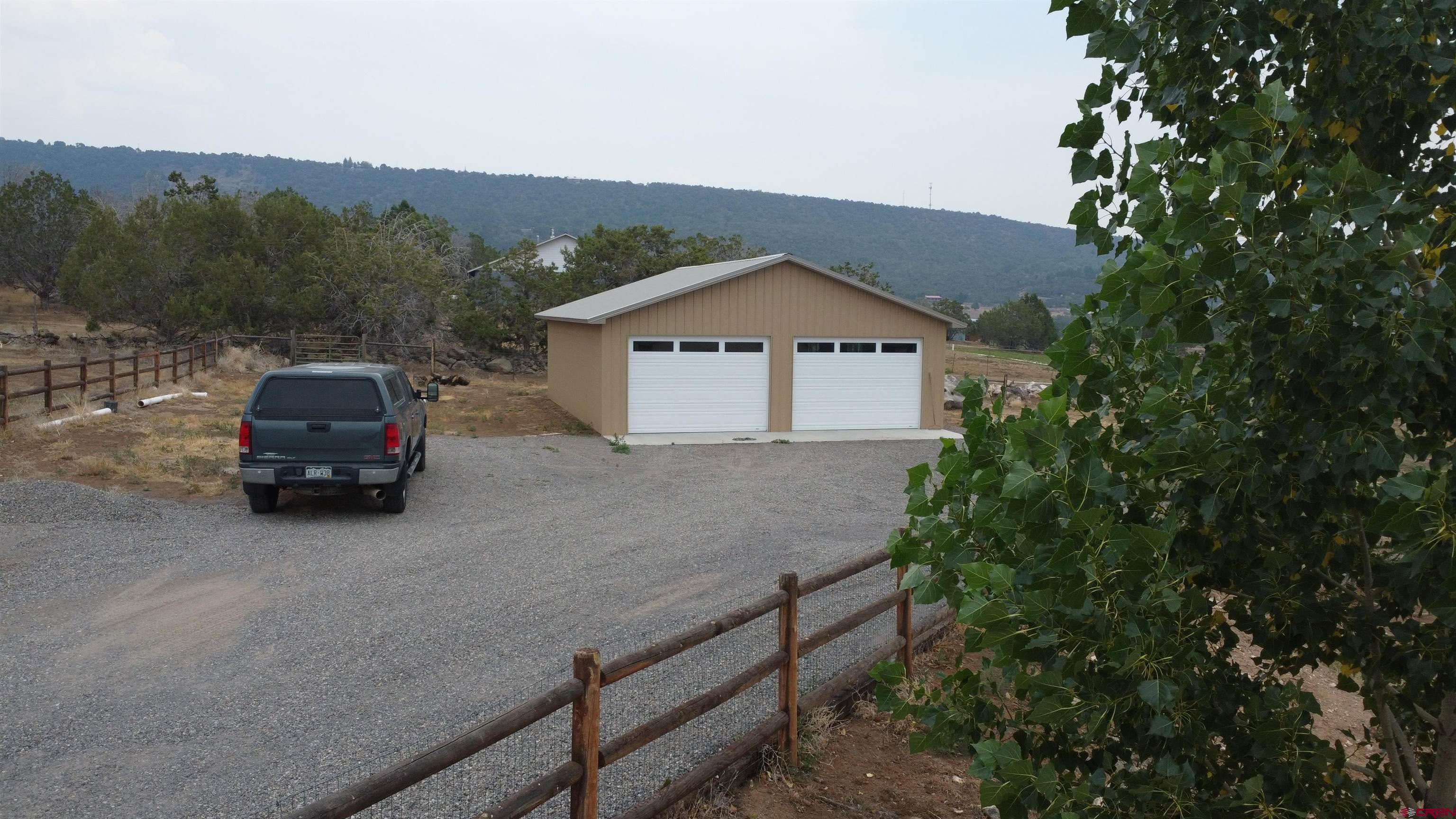 18200 Surface Creek Road Cedaredge, CO 81413 - Photo 9 of 39 a car parked in front of a house with a small yard