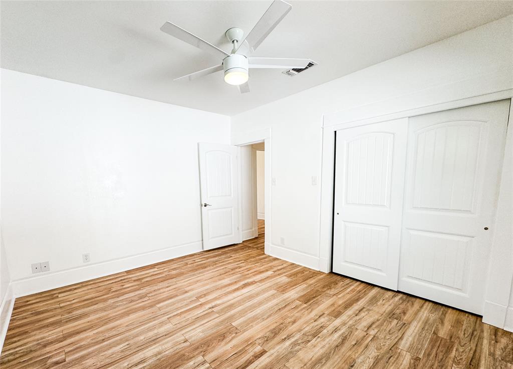 904 West 7th Street Cisco, TX 76437 - Photo 20 of 37 an empty room with wooden floor and fan