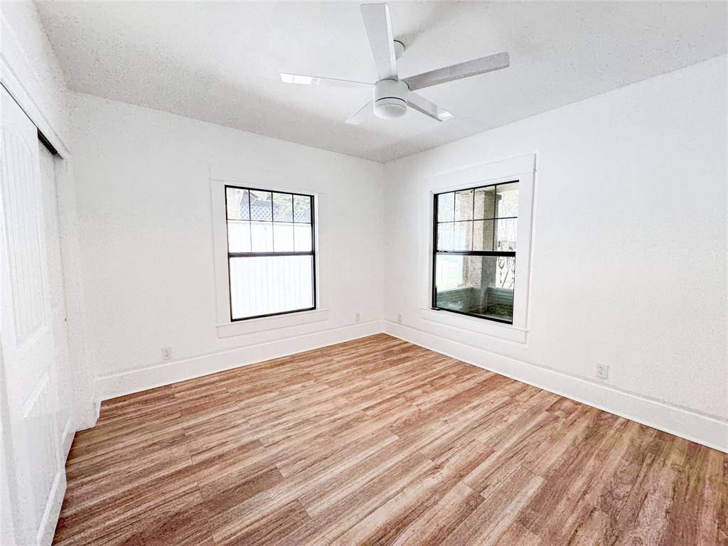 904 West 7th Street Cisco, TX 76437 - Photo 21 of 37 a view of an empty room with a window and wooden floor