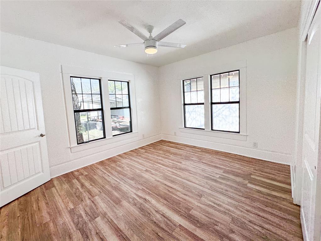 904 West 7th Street Cisco, TX 76437 - Photo 32 of 37 an empty room with wooden floor and windows