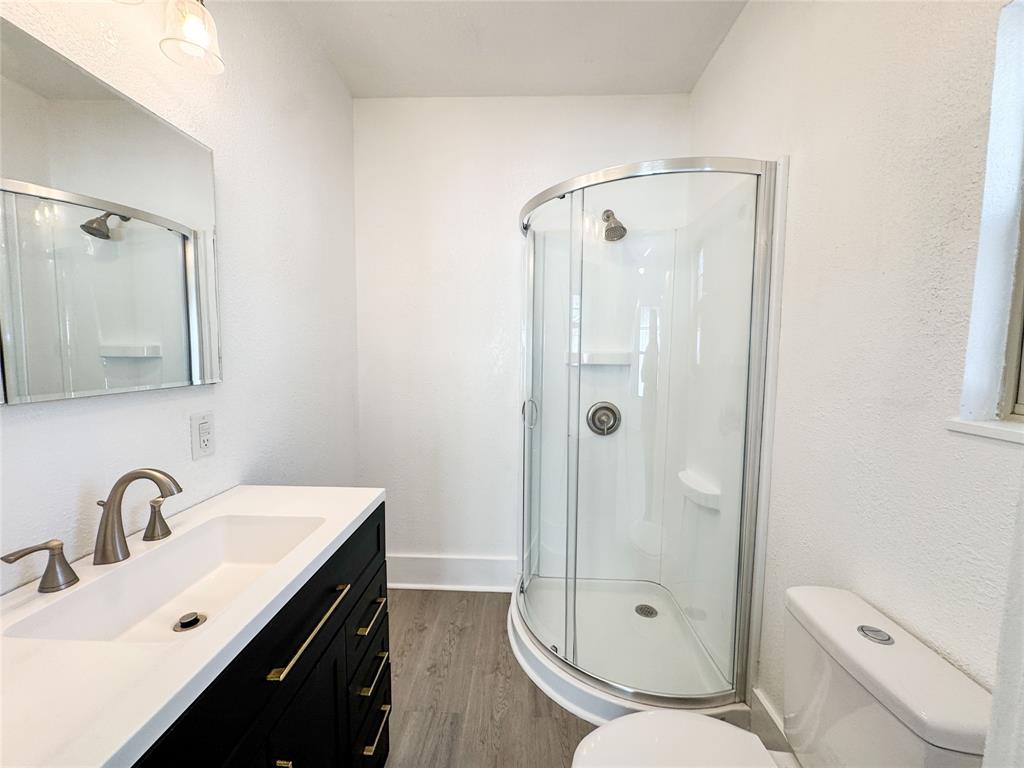 904 West 7th Street Cisco, TX 76437 - Photo 33 of 37 a bathroom with a shower sink mirror vanity and toilet