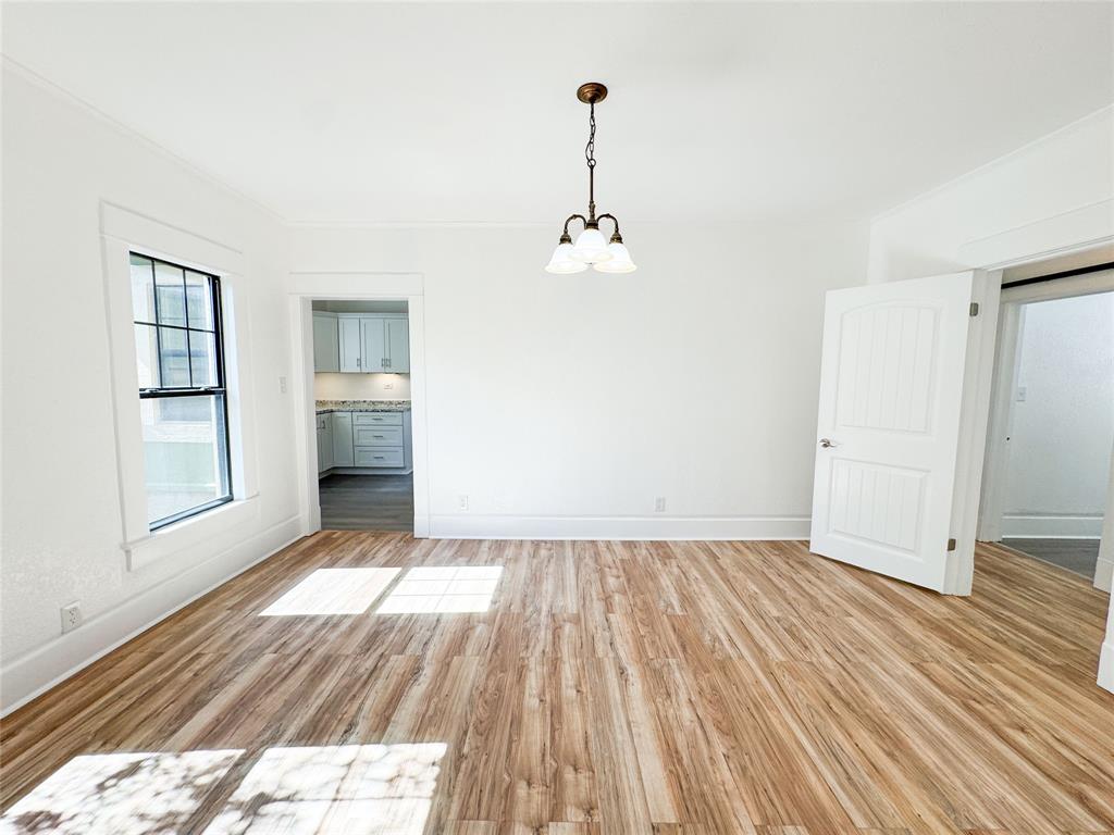 904 West 7th Street Cisco, TX 76437 - Photo 9 of 37 a view of a room with wooden floor and a ceiling fan