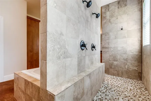 a bathroom with a sink a bathtub a mirror and a shower