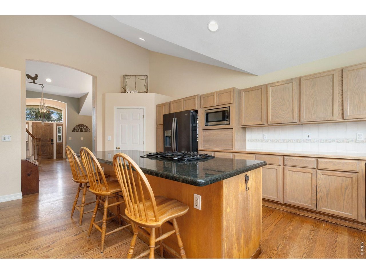 1055 Coho Run Fort Collins, CO 80524 - Photo 13 of 43 a kitchen with stainless steel appliances granite countertop a stove top oven a sink dishwasher and white cabinets with wooden floor