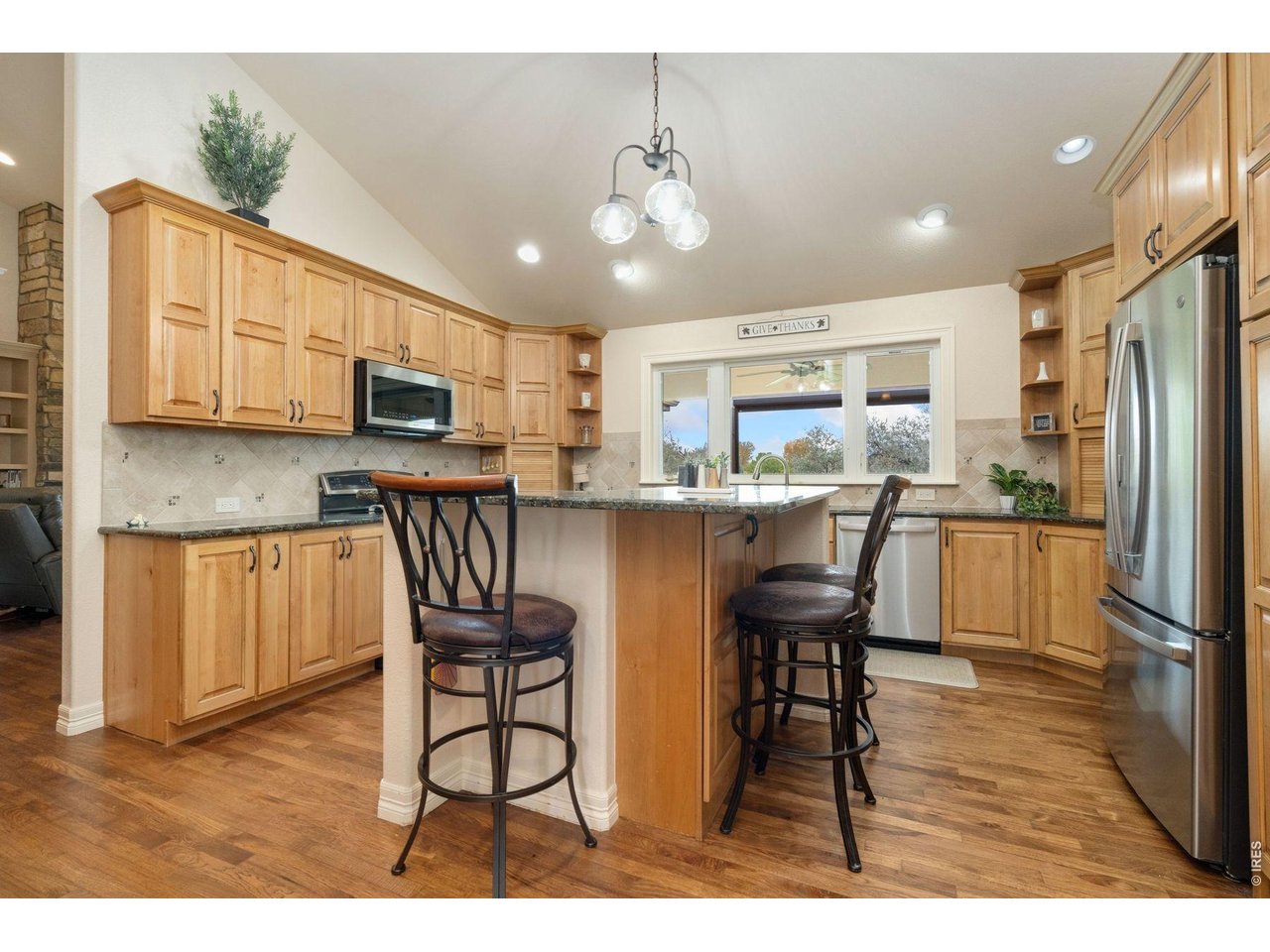 1055 Coho Run Fort Collins, CO 80524 - Photo 4 of 43 a kitchen with stainless steel appliances kitchen island granite countertop a refrigerator a stove a sink dishwasher with a dining table and chairs
