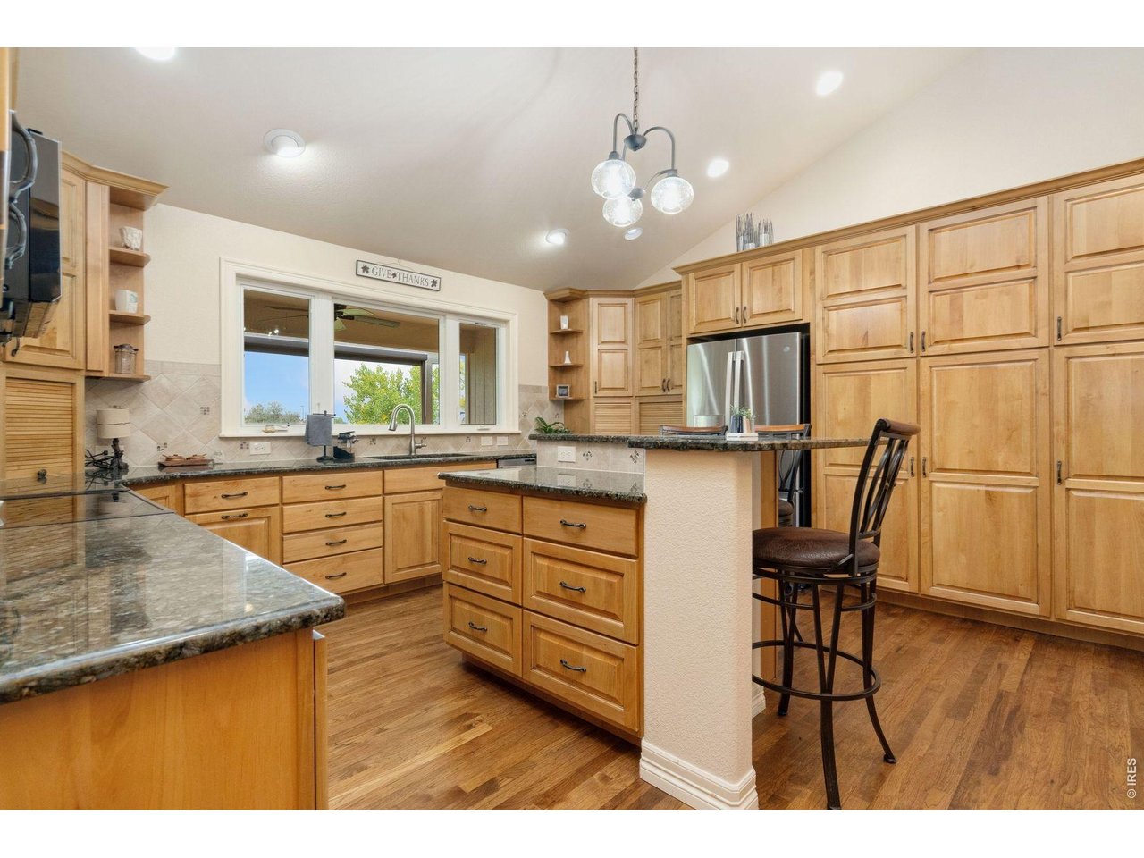 1055 Coho Run Fort Collins, CO 80524 - Photo 5 of 43 a kitchen with stainless steel appliances granite countertop a sink dishwasher a stove refrigerator and cabinets with wooden floor