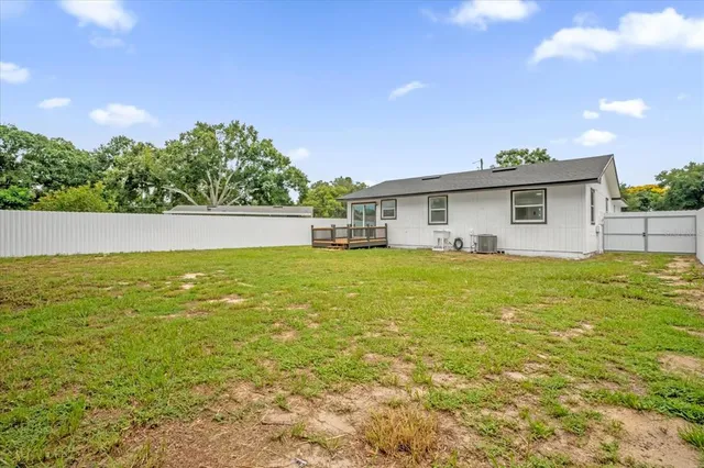 a front view of house with yard and trees in the background