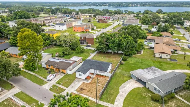 an aerial view of a house with a garden and lake view