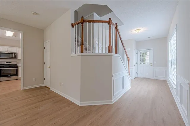 a view of an empty room with window and wooden floor
