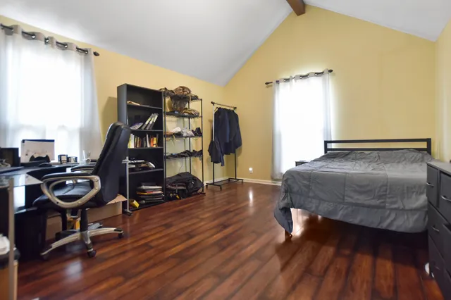 a bedroom with a bed and wooden floor