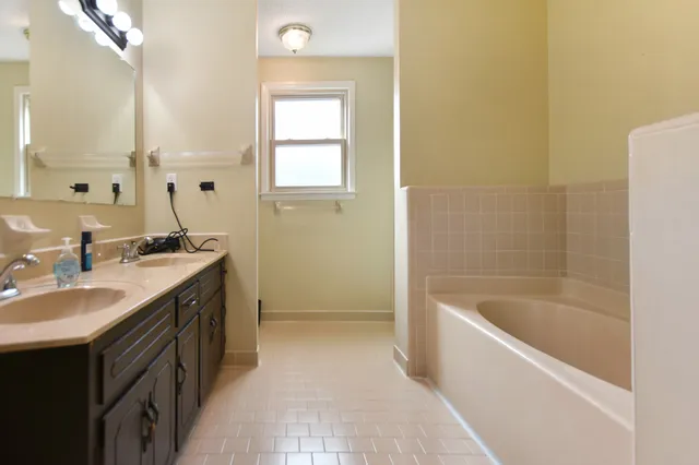 a bathroom with a bathtub sink and mirror