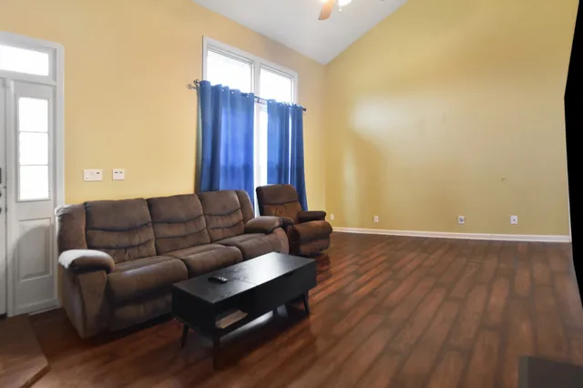 a living room with furniture and wooden floor