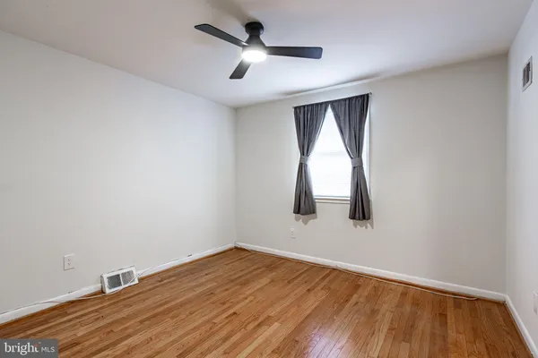 an empty room with a window and wooden floor