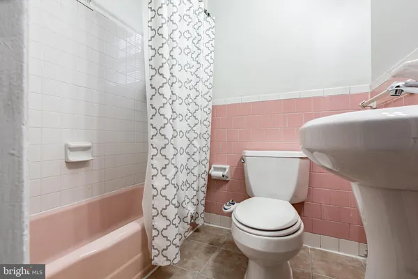 a white toilet sitting next to a bath tub