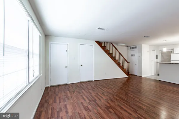a view of a hallway with wooden floor and staircase