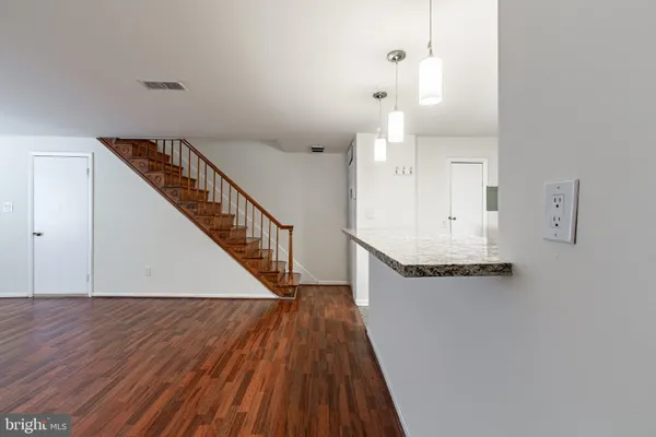 a view of a hallway with wooden floor and staircase
