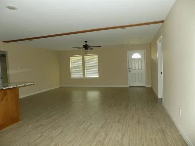 an empty room with a window and a fan