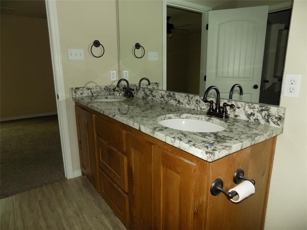 2007 Brown Loop Poolville, TX 76487 - Photo 17 of 32 a bathroom with a granite countertop sink and a mirror