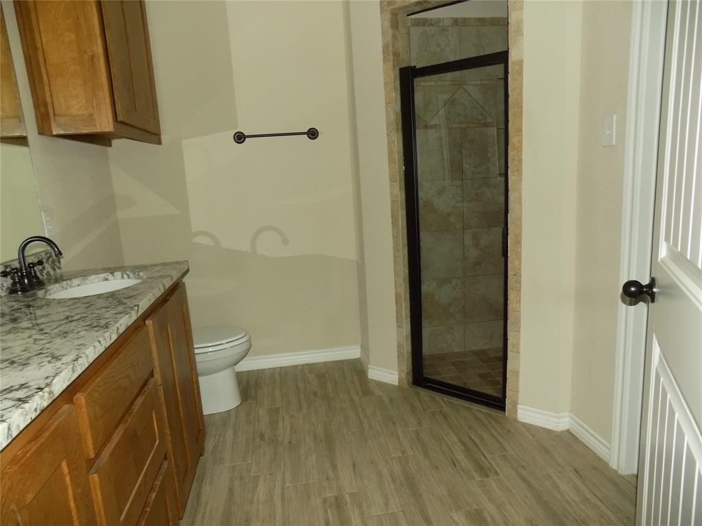 2007 Brown Loop Poolville, TX 76487 - Photo 19 of 32 a bathroom with a granite countertop sink toilet and shower