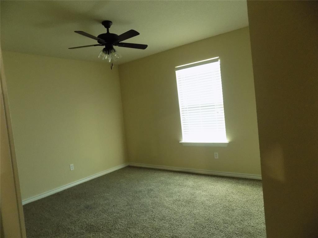 2007 Brown Loop Poolville, TX 76487 - Photo 23 of 32 an empty room with a window and a ceiling fan