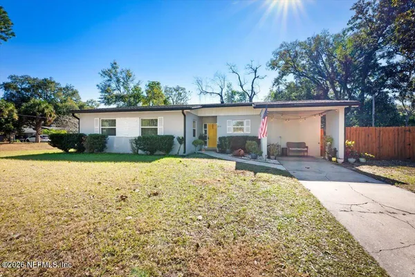 a front view of house with yard and trees in the background