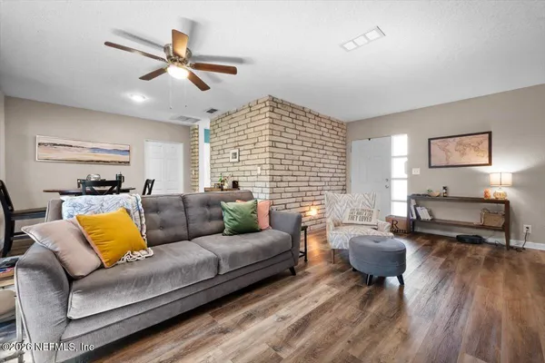 a living room with furniture wooden floor and window