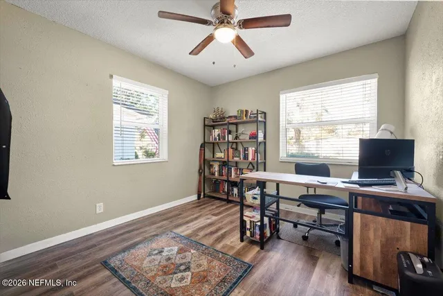 a workspace with wooden floor and a window