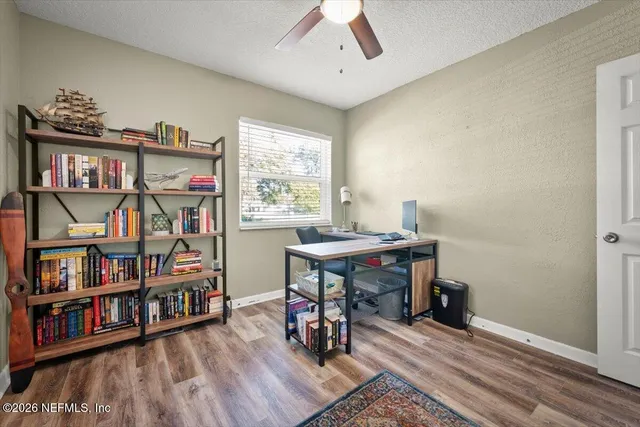 a view of a workspace with furniture and book shelf