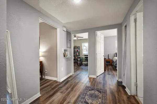 a view of a hallway with wooden floor a bathroom and a sink