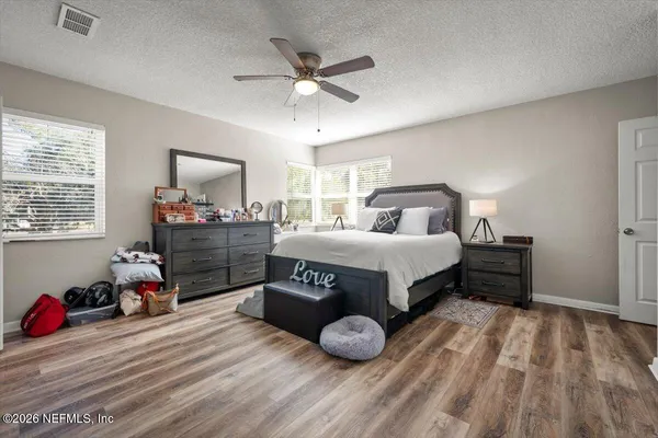 a bedroom with a bed and wooden floor