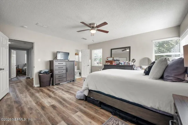 a spacious bedroom with a bed and dresser