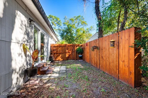 a view of a house with backyard and wooden fence