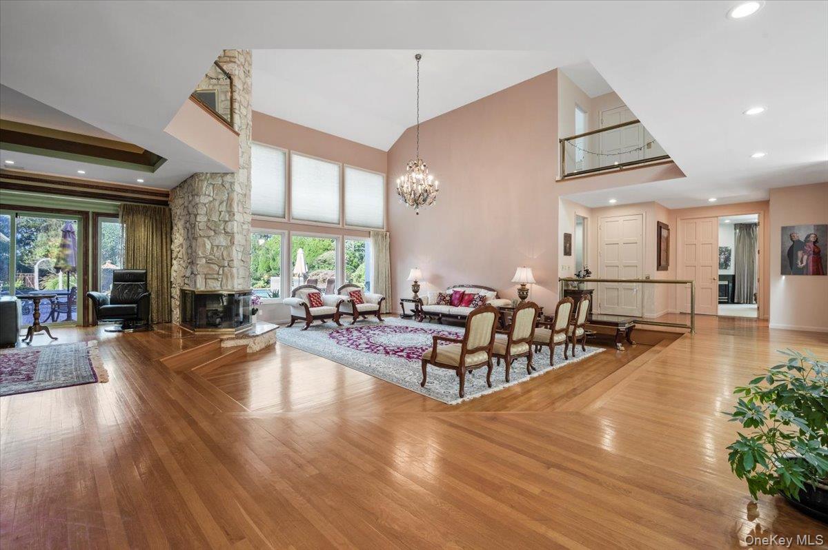 12 Ridge Court Glen Head, NY 11545 - Photo 5 of 46 Living room with recessed lighting, wood-type flooring, plenty of natural light, high vaulted ceiling, and a chandelier