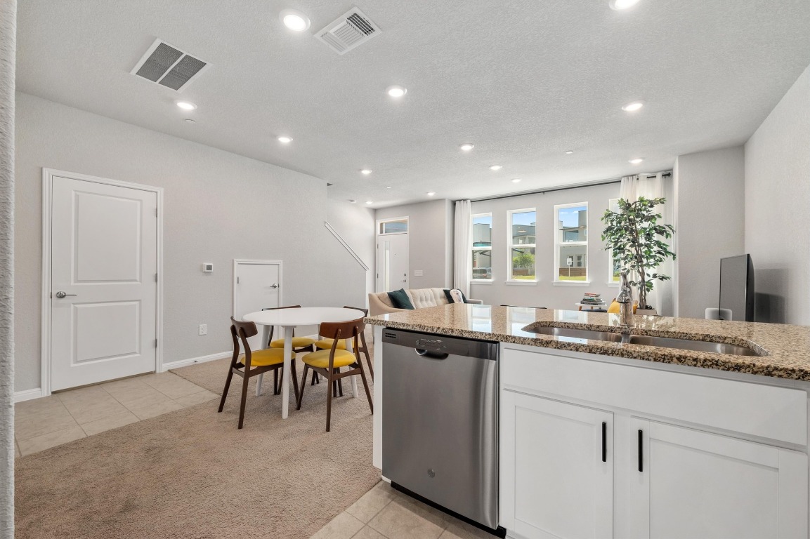 9015 Cattle Baron Path, Unit 403 Austin, TX 78747 - Photo 13 of 40 a kitchen with a sink and chairs