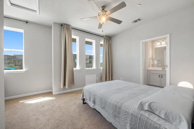 a bedroom with a large bed and a chandelier
