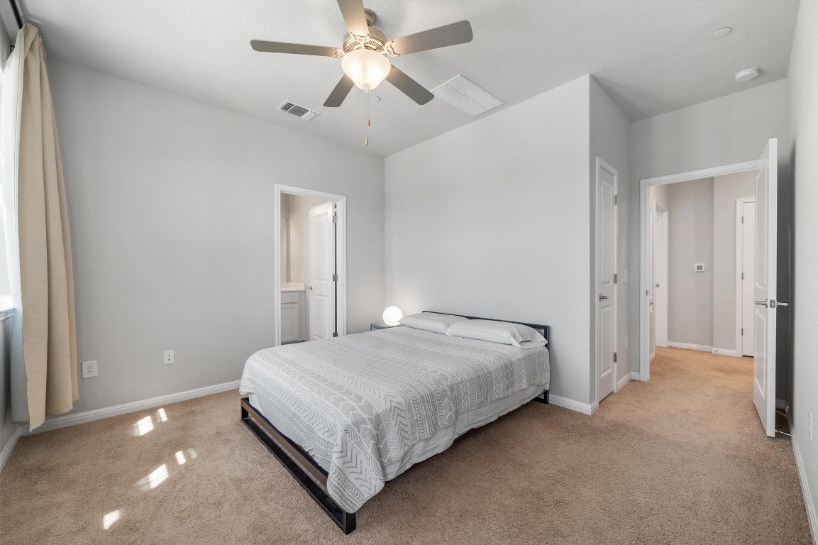 9015 Cattle Baron Path, Unit 403 Austin, TX 78747 - Photo 16 of 40 a bedroom with a bed and a ceiling fan