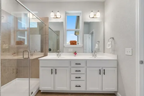 a bathroom with a sink double vanity and a mirror